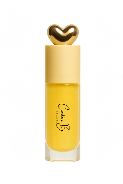 Carter B. Beauty Lippenöl in der Farbe GINGER – feuchtigkeitsspendendes, natürliches Lip Oil mit gelben Akzenten und pflegender Formel, präsentiert vor einem gelben Hintergrund. (stehend)