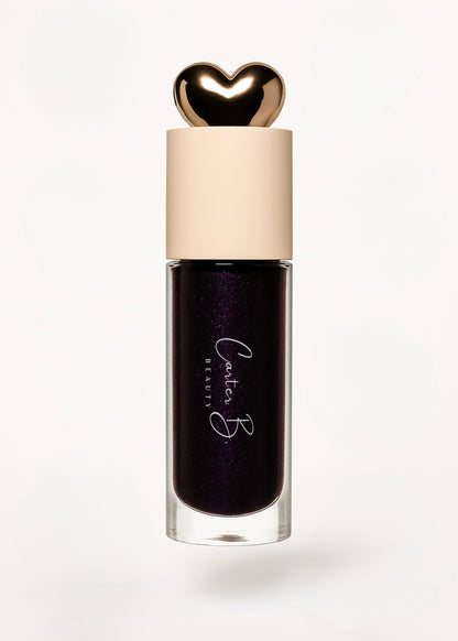 Carter B. Beauty Lippenöl in der Farbe BLACK CURRANT – feuchtigkeitsspendendes, natürliches Lip Oil mit beerigen Akzenten und pflegender Formel, präsentiert vor einem dunklen Hintergrund. (stehend)