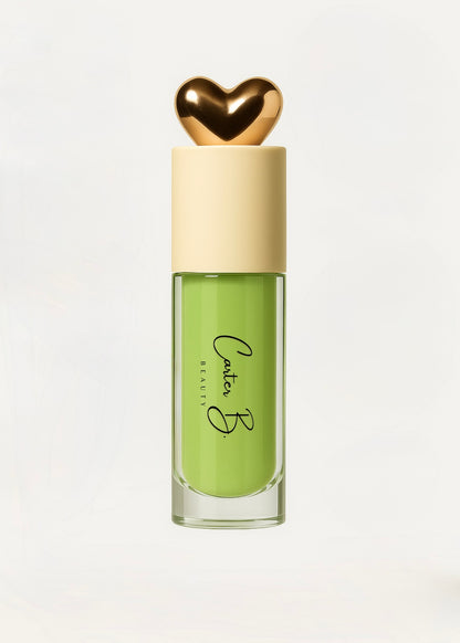 Carter B. Beauty Lippenöl in der Farbe AVOCADO – feuchtigkeitsspendendes, natürliches Lip Oil mit grünen Akzenten und pflegender Formel, präsentiert vor einem grünen Hintergrund. (stehend)