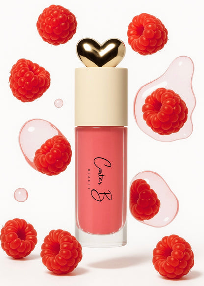 Carter B. Beauty Lippenöl in der Farbe RAPSBERRY – feuchtigkeitsspendendes, natürliches Lip Oil mit pinken Akzenten und pflegender Formel, präsentiert vor einem beerigen Hintergrund. (stehend mit Himbeeren)