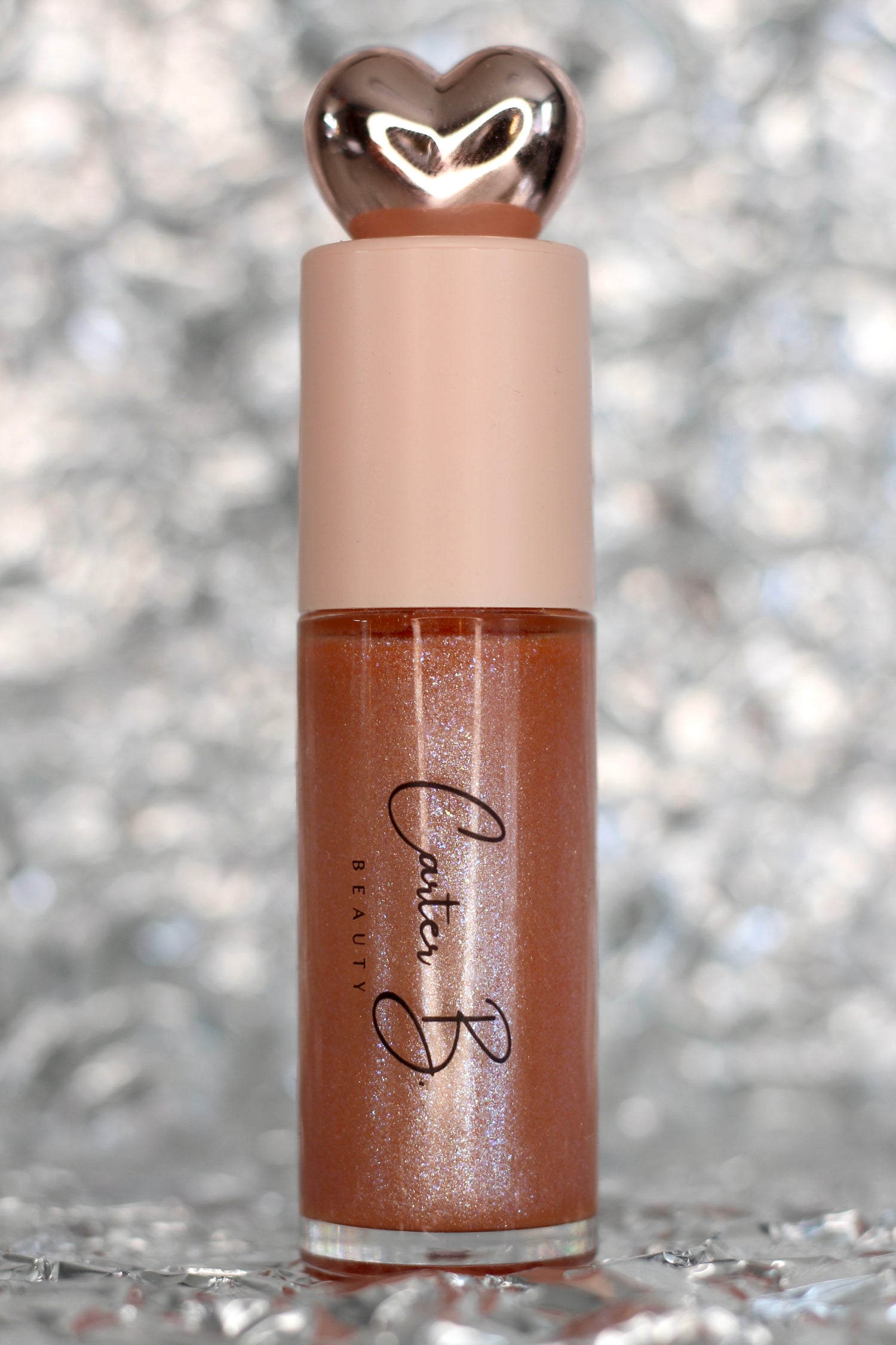 Lipgloss in der Farbe BRILLIANT, mit silbernen Hintergrund. Ein nudefarbener Lipgloss, mit Glitzerpartikeln