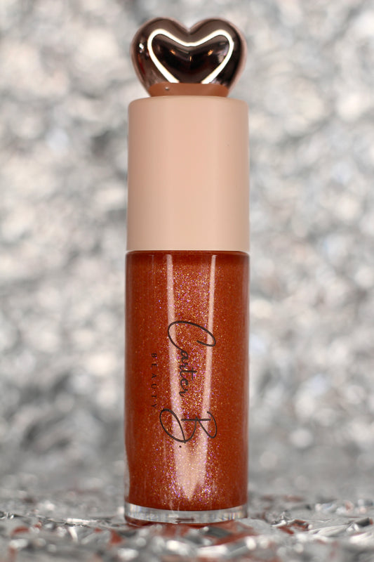 Lipgloss in der Farbe PISCES, mit silbernen Hintergrund. Ein bräunlicher Lipgloss, mit Glitzerpartikeln