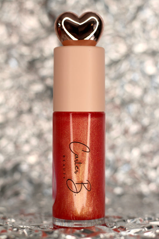 Lipgloss in der Farbe GEORGIA PEACH, mit silbernen Hintergrund. Ein korallfarbender Lipgloss, mit Schimmer