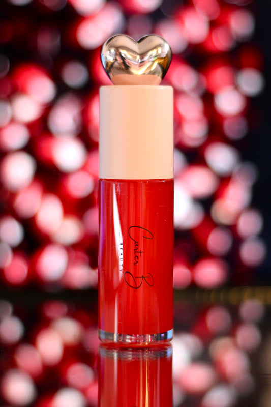 Carter B. Beauty Lippenöl in der Farbe POMEGRANATE – feuchtigkeitsspendendes, natürliches Lip Oil mit roten Akzenten und pflegender Formel, präsentiert vor einem roten Hintergrund. (stehend)