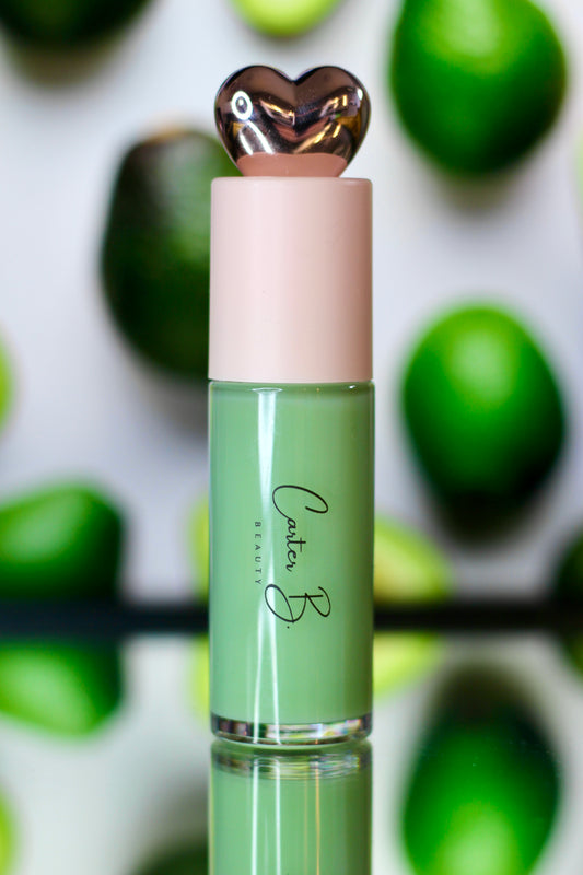 Carter B. Beauty Lippenöl in der Farbe AVOCADO – feuchtigkeitsspendendes, natürliches Lip Oil mit grünen Akzenten und pflegender Formel, präsentiert vor einem grünen Hintergrund. (stehend)