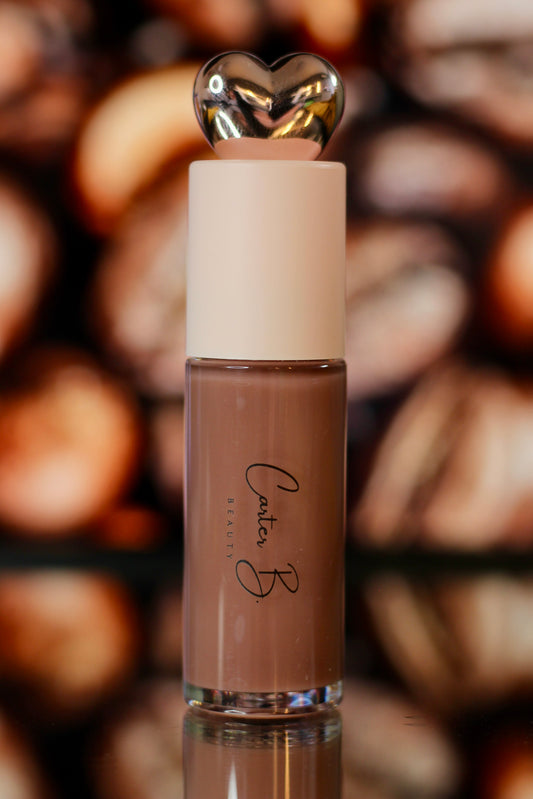 Carter B. Beauty Lippenöl in der Farbe LATTE – feuchtigkeitsspendendes, natürliches Lip Oil mit nudefarbenden Akzenten und pflegender Formel, präsentiert vor einem braunen Hintergrund. (stehend)