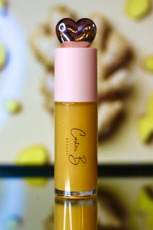 Carter B. Beauty Lippenöl in der Farbe GINGER – feuchtigkeitsspendendes, natürliches Lip Oil mit gelben Akzenten und pflegender Formel, präsentiert vor einem gelben Hintergrund. (stehend)
